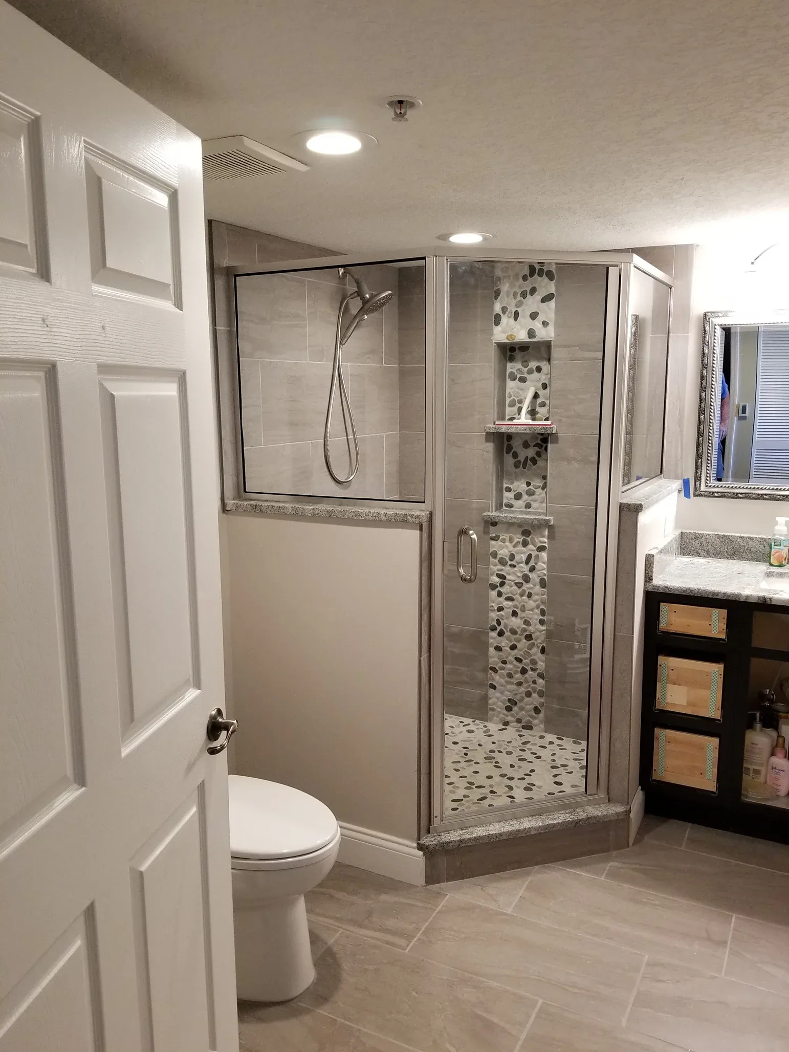 Framed neo angle shower pebble column in Rockledge
