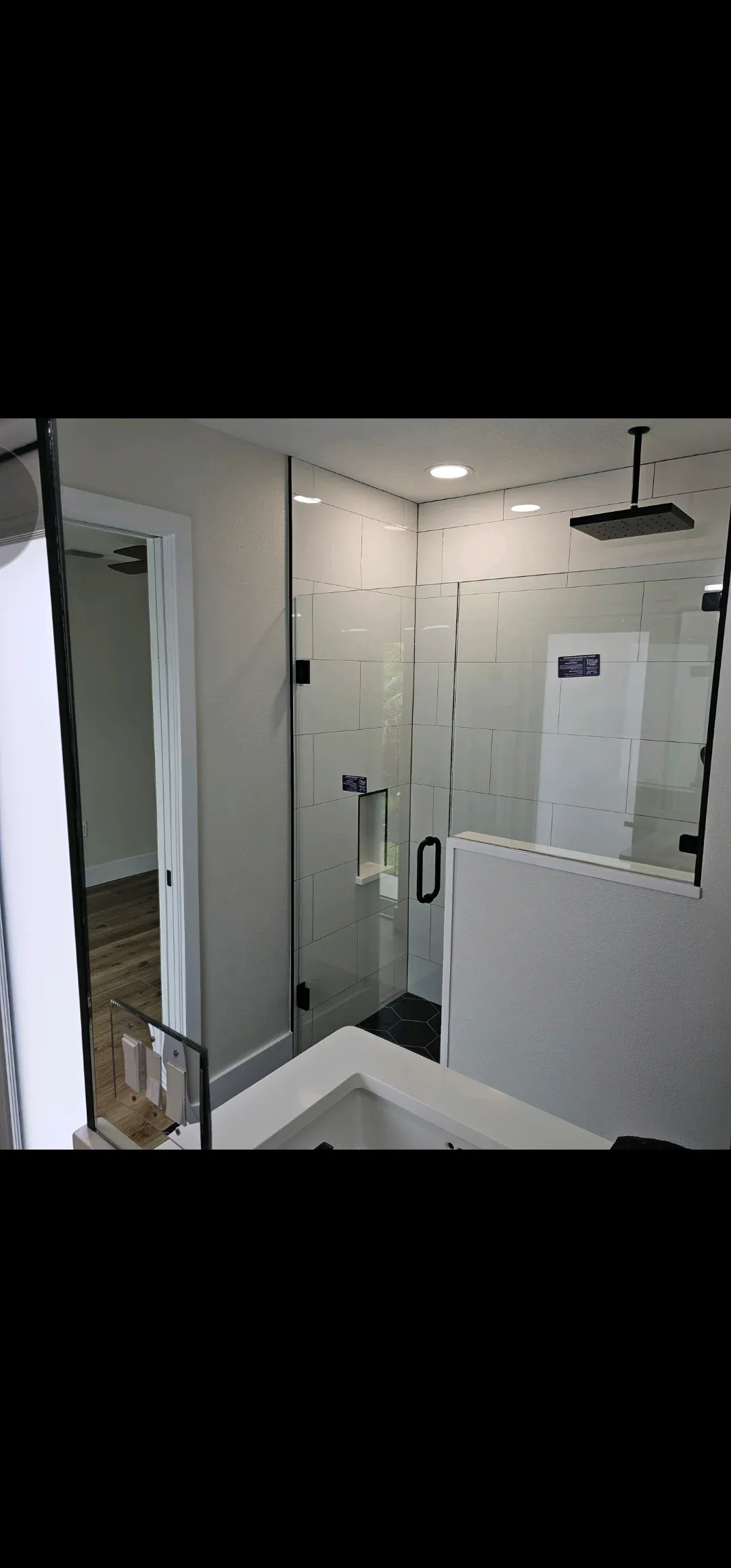 Matte black hardware frameless shower hex floor in Cocoa